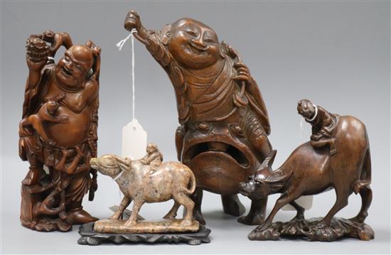 Three Chinese figural wood carvings and a soapstone carving of a child riding a water buffalo,